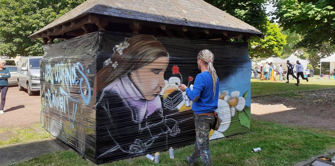 Peintre entrain de peindre une bâche